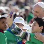 Foto di papa Francesco con fanciulli e smartphone